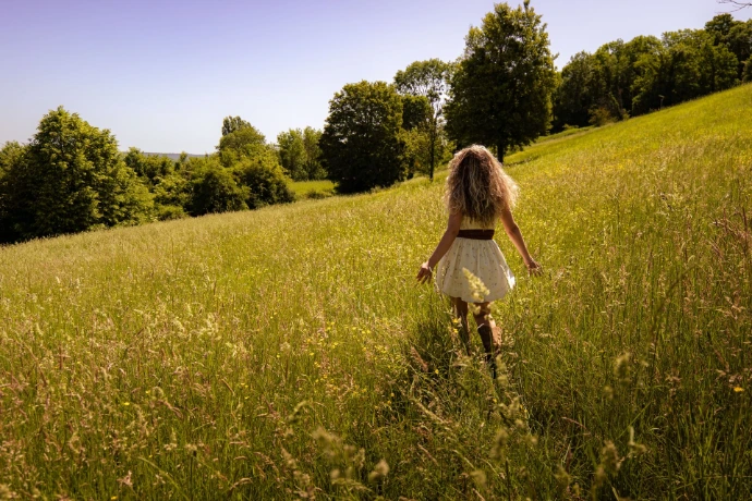 Le modèle du shooting photo à Gaillon est de dos, face au grand champ de blé