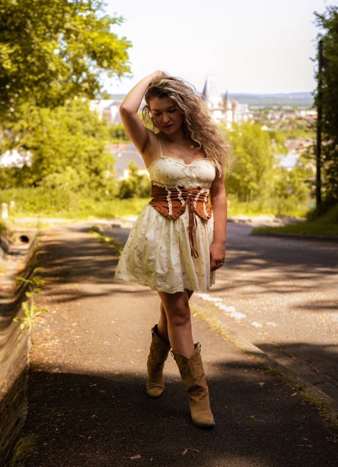 La femme prise en photo pose face à l'objectif, le château de Gaillon en arrière-plan