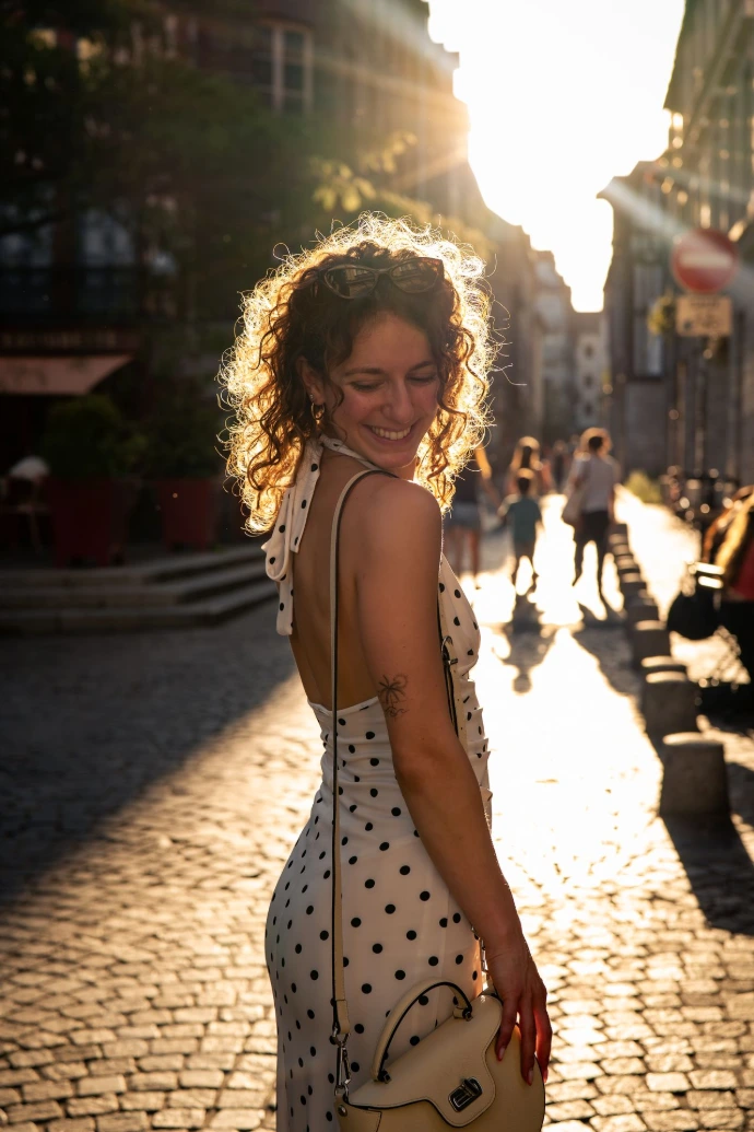 Photo plein pied d'Ellia dans une rue de Rouen pour son shooting photo. Souriante et de dos, Ellia pose en extérieur.