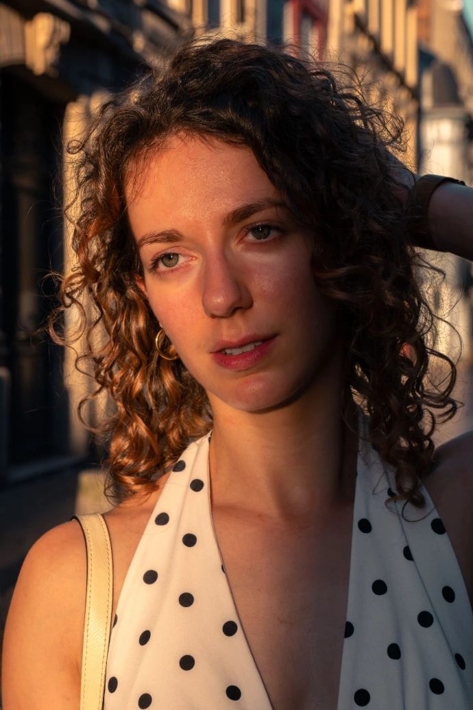 Gros plan d'Ellia durant son shooting photo à Rouen. Nous voyons les détails des yeux, des reflets et de son visage éclairé par le soleil.